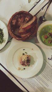 Tantalizing French meal featuring bread, soup, and more on a Parisian table.